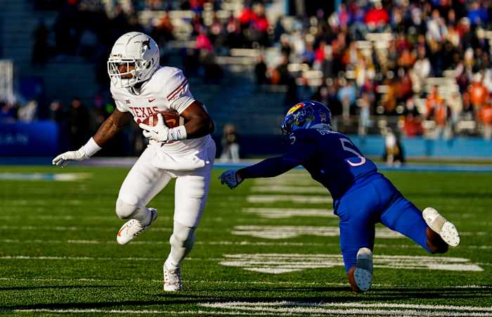 Texas Longhorns wide receiver Savion Red (17) runs with the ball past Kansas Jayhawks safety O.J. Burroughs (5) during the first half at David Booth Kansas Memorial Stadium.